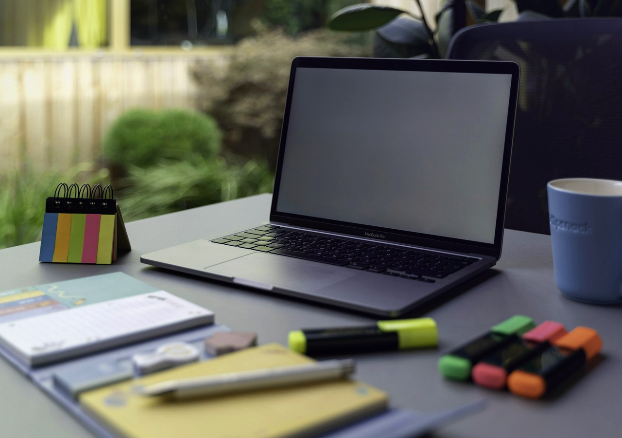 Realistic CMS planning workspace with a laptop, notebook, markers, and sticky notes